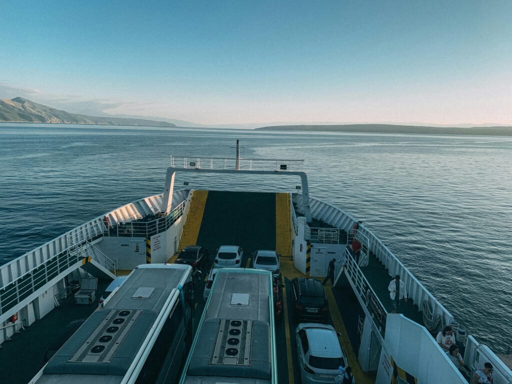 Vehicles aboard a ferry crossing calm ocean waters, highlighting coastal transportation and scenic travel.